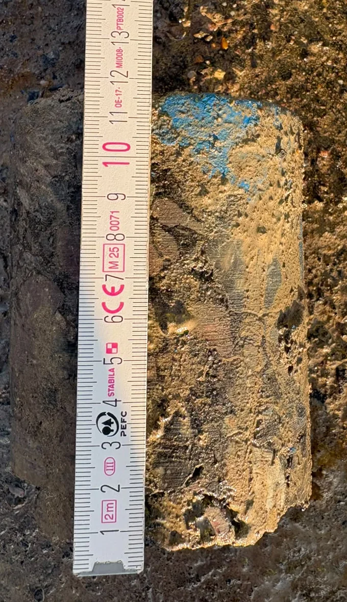 Tarmac core taken from the estate road laid beside a folding rule, measuring about 116 mm